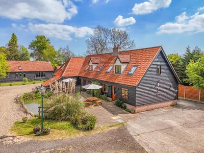 a house with an orange roof and a patio at Chestnut Tree Barn in Saint Lawrence