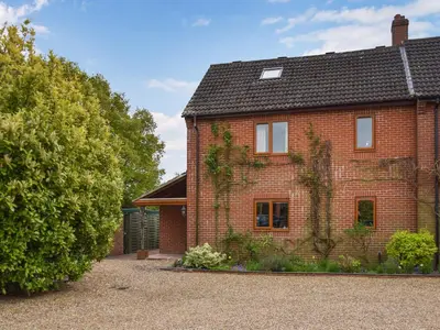 a red brick house with a black roof at Swallowdale in Flordon