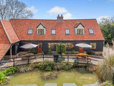 a house with a pond in front of it at Treetops - Uk49523 in Saint Lawrence