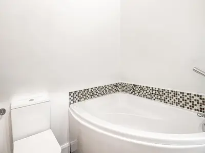 a white bath tub in a bathroom with a tiled wall at Treetops - Uk49523 in Saint Lawrence