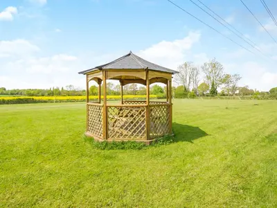 a gazebo in the middle of a grass field at Treetops - Uk49523 in Saint Lawrence