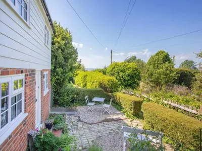 a patio with a table and chairs next to a house at Island Cottage in West Mersea