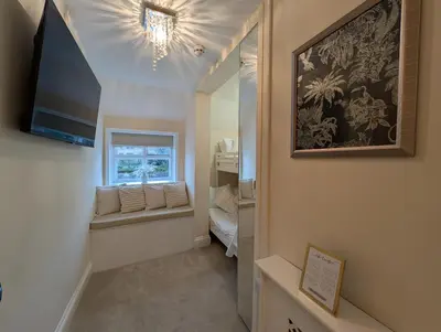 a small hallway with a window and a television at A historic Pub with a modern twist - The Greyhound in Bury Saint Edmunds