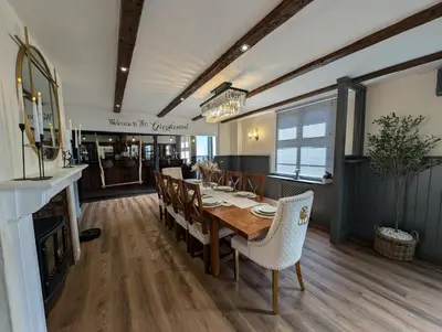 a dining room with a wooden table and chairs at A historic Pub with a modern twist - The Greyhound in Bury Saint Edmunds