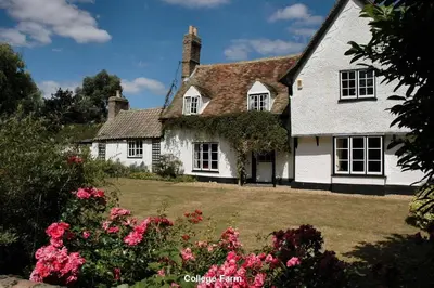 a white house with flowers in front of it at The White Barn near Cambridge in Huntingdon