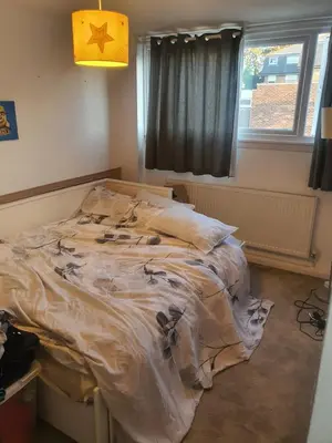 an unmade bed in a room with a window at One bed room in three bed room house in Hoddesdon