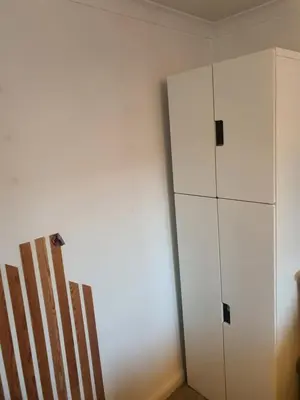 a room with a white cabinet next to a wall at One bed room in three bed room house in Hoddesdon