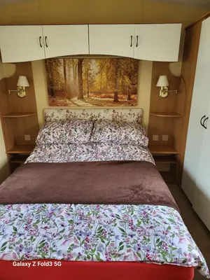 a large bed in a bedroom with a painting on the wall at Home from home in Holland-on-Sea