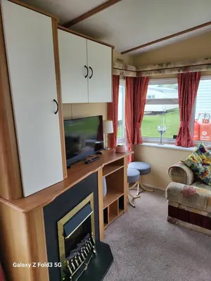 a living room with a fireplace and a tv at Home from home in Holland-on-Sea