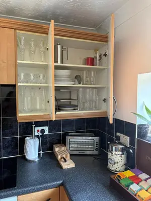 a kitchen with cabinets with glasses and dishes at Next to double Nobel Laureate in Trumpington