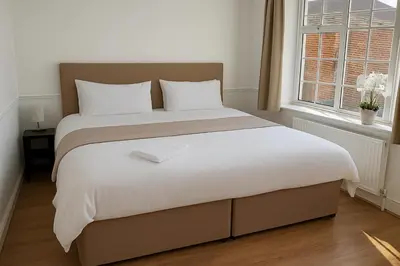 a large bed in a bedroom with a window at Stansted Stop Over in Takeley