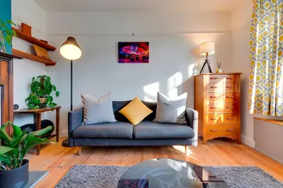 a living room with a blue couch with pillows at Stylish and Modern Flat with Free Parking Pass the Keys in Cambridge