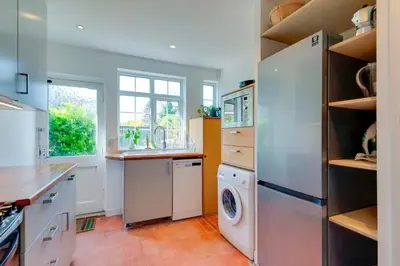 a kitchen with a refrigerator and a washer and dryer at Stylish and Modern Flat with Free Parking Pass the Keys in Cambridge