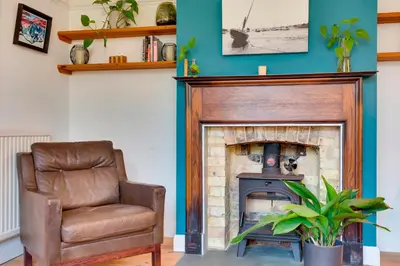 a living room with a chair and a fireplace at Stylish and Modern Flat with Free Parking Pass the Keys in Cambridge