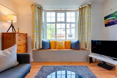 a living room with a couch and a window at Stylish and Modern Flat with Free Parking Pass the Keys in Cambridge