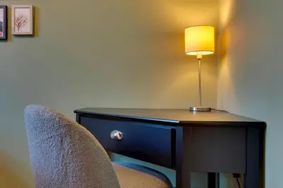 a desk with a lamp and a chair at Stylish and Modern Flat with Free Parking Pass the Keys in Cambridge