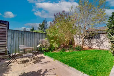 a yard with a bench and a fence at Stylish and Modern Flat with Free Parking Pass the Keys in Cambridge