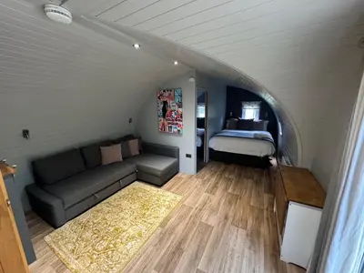 a living room with a couch and a bed at All Manor Of Events - Glamping Pods in Henley
