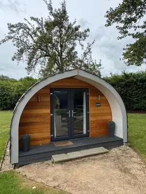 a small dome house with a door in the grass at All Manor Of Events - Glamping Pods in Henley