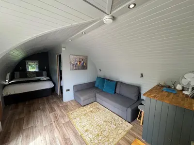 a living room with a couch and a bed at All Manor Of Events - Glamping Pods in Henley