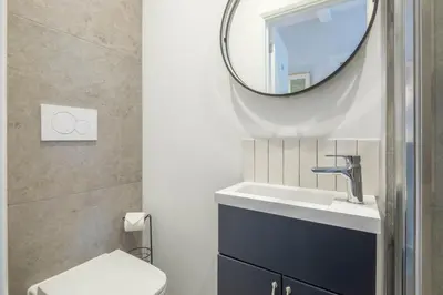 a bathroom with a sink and a mirror at Modern 4-Bedroom Detached Home in Central Cambridge with Parking in Cambridge