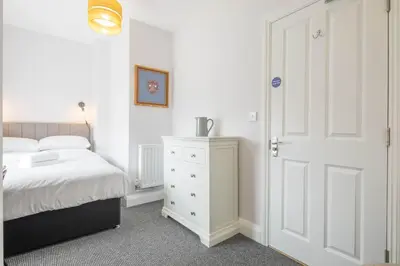 a bedroom with a white bed and a white door at Modern 4-Bedroom Detached Home in Central Cambridge with Parking in Cambridge