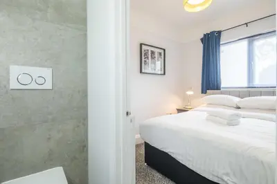 a bedroom with a large white bed and a window at Modern 4-Bedroom Detached Home in Central Cambridge with Parking in Cambridge