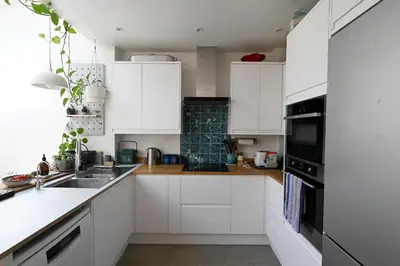 a white kitchen with white cabinets and a sink at The Avenue in Cherry Hinton