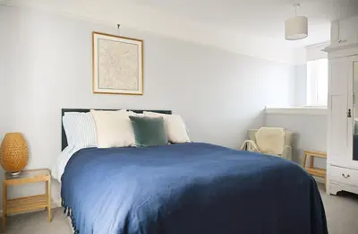a bedroom with a bed with a blue blanket at The Avenue in Cherry Hinton