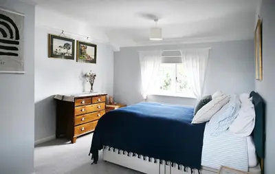 a bedroom with a blue bed and a window at The Avenue in Cherry Hinton