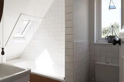 a white bathroom with a sink and a window at The Avenue in Cherry Hinton