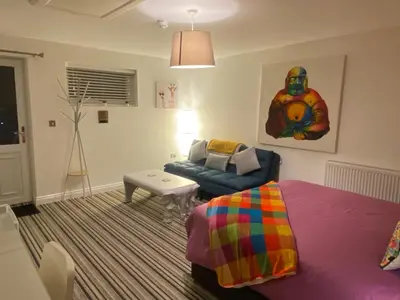 a living room with a bed and a couch at Sanctuary Rooms in Brightlingsea