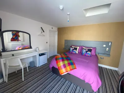 a bedroom with a bed and a desk and a mirror at Sanctuary Rooms in Brightlingsea
