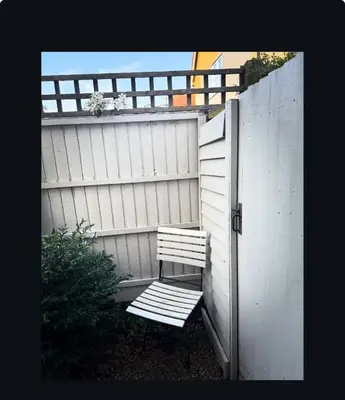 a wooden bench sitting next to a fence at Upstairs at Rumblebees in Felsted Station