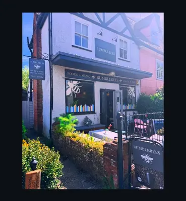 a store with a sign in the window of a building at Upstairs at Rumblebees in Felsted Station
