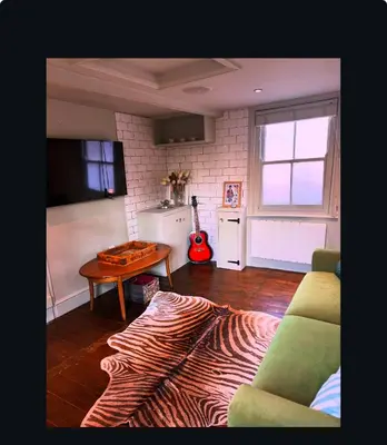 a living room with a couch and a table at Upstairs at Rumblebees in Felsted Station