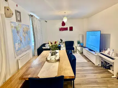 a living room with a table and a tv at Home in Cambridge in Long Stanton