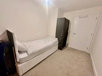 a small room with a bed and a door at Home in Cambridge in Long Stanton