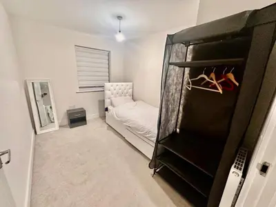 a small room with a bed and a closet at Home in Cambridge in Long Stanton