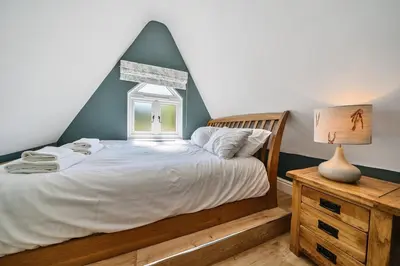 a bedroom with a bed and a window at The Folly, Thorpe Forest in Brettenham
