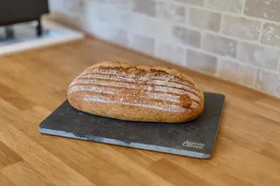 a loaf of bread sitting on a spatula on a table at The Folly, Thorpe Forest in Brettenham