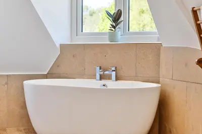 a white sink in a bathroom with a window at The Folly, Thorpe Forest in Brettenham