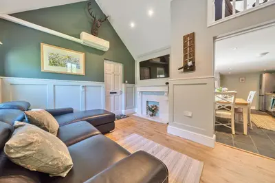 a living room with a couch and a fireplace at The Folly, Thorpe Forest in Brettenham