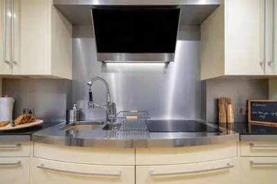 a kitchen with a sink and a microwave at Tower Cottage - Medieval Grid Townhouse in Bury Saint Edmunds
