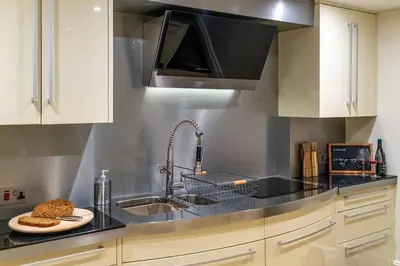 a kitchen with a sink and a microwave at Tower Cottage - Medieval Grid Townhouse in Bury Saint Edmunds