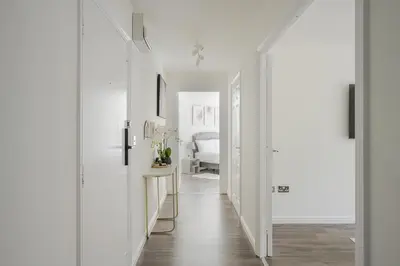 a hallway with white walls and a white bedroom at 2 Luxurious Apartments with Free Parking near Chelmsford City in Chelmsford