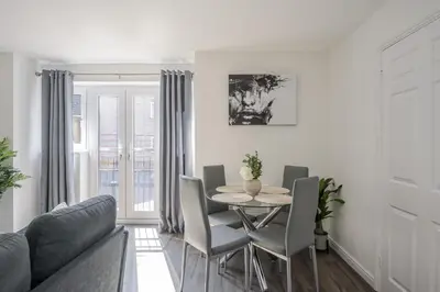a living room with a table and chairs at 2 Luxurious Apartments with Free Parking near Chelmsford City in Chelmsford