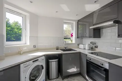 a kitchen with a washing machine and a sink at 2 Luxurious Apartments with Free Parking near Chelmsford City in Chelmsford