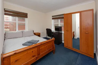 a bedroom with a bed and a desk with a computer at Spacious 3 bed flat in Colchester - Free parking in Hythe