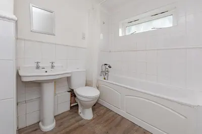a white bathroom with a toilet and a sink at Spacious 3 bed flat in Colchester - Free parking in Hythe